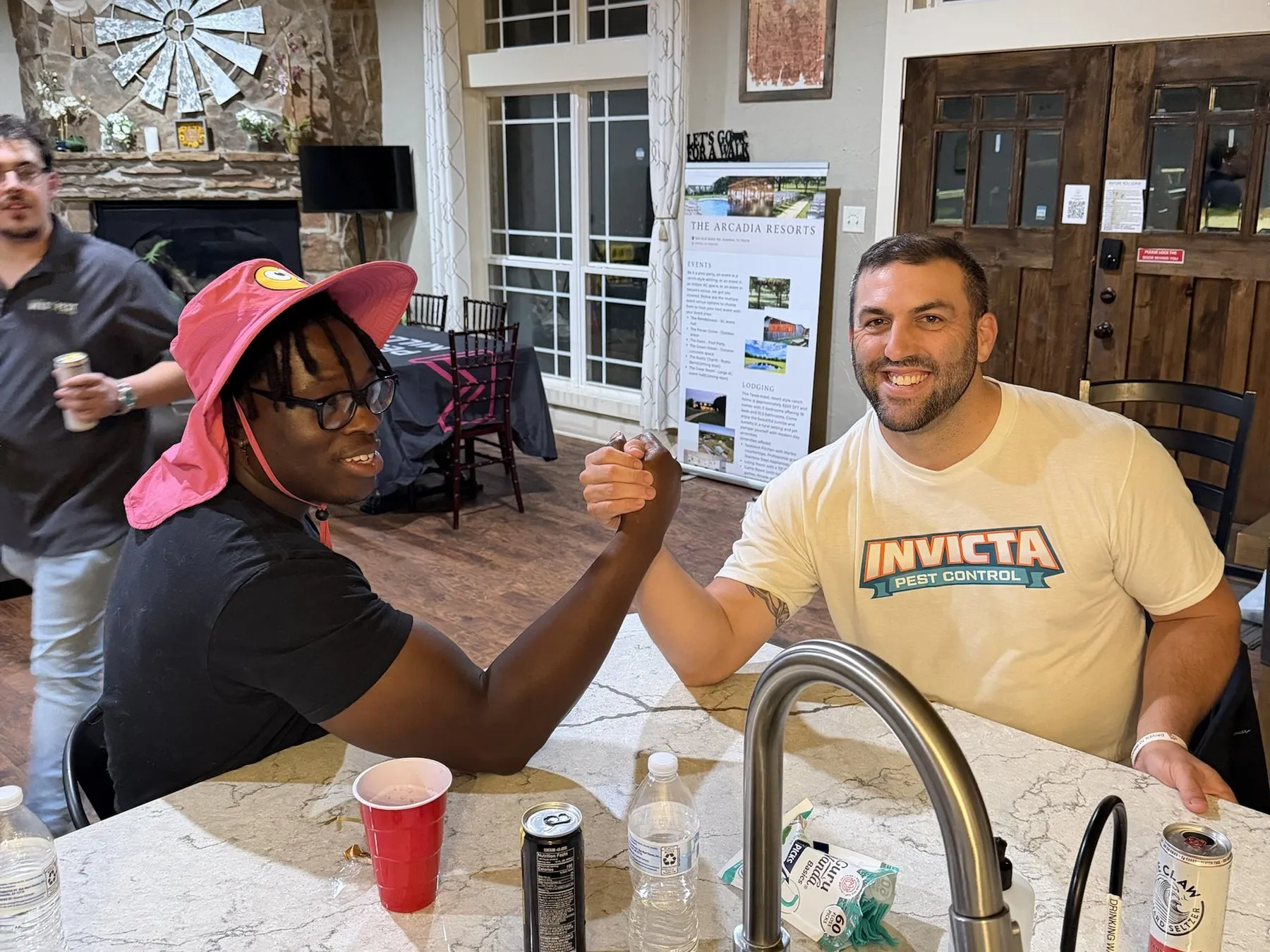 Two members arm wrestling at the kitchen island at PCM House