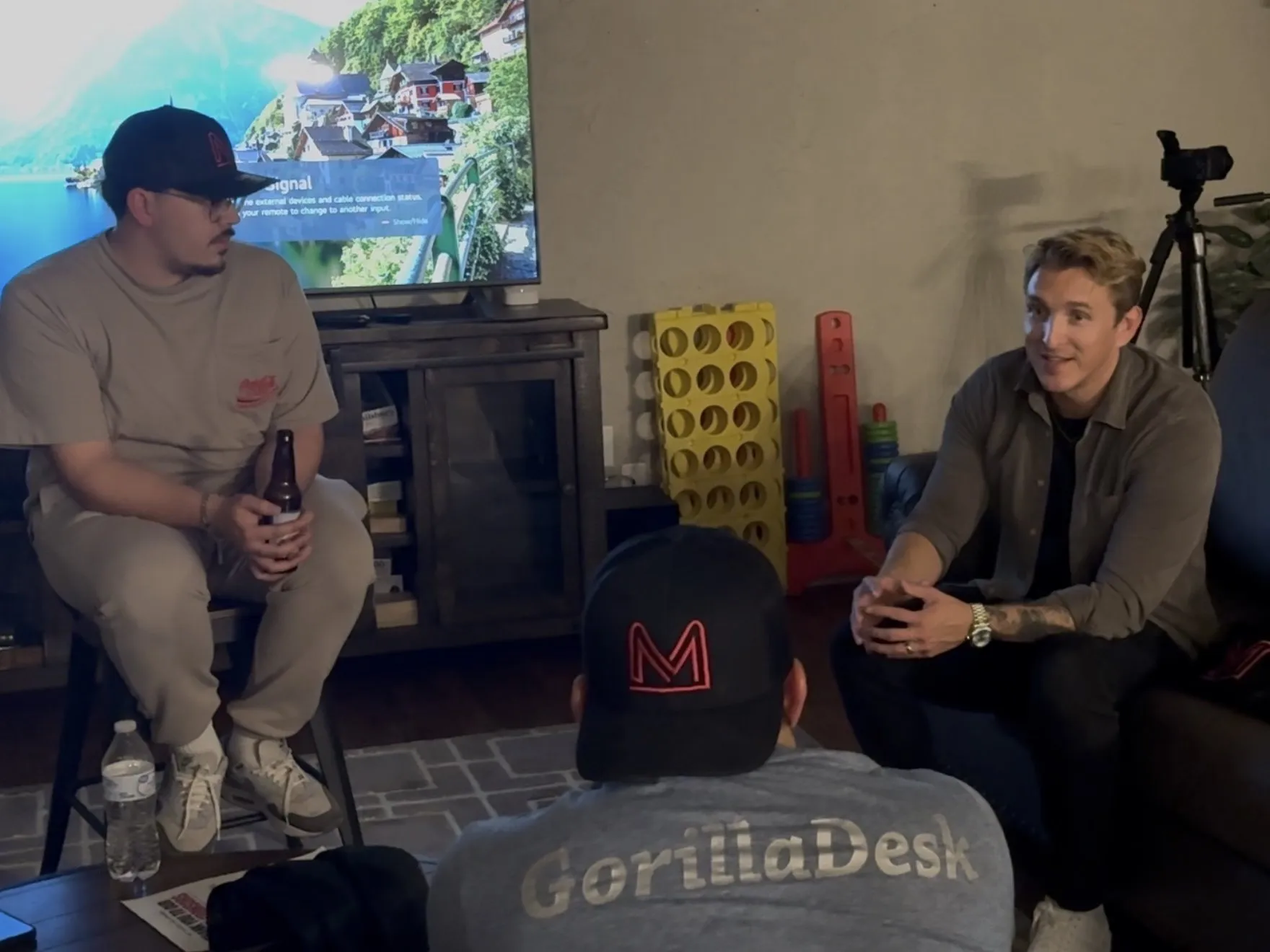 Jake Sheldon talking with members on the couch at PCM House in the evening