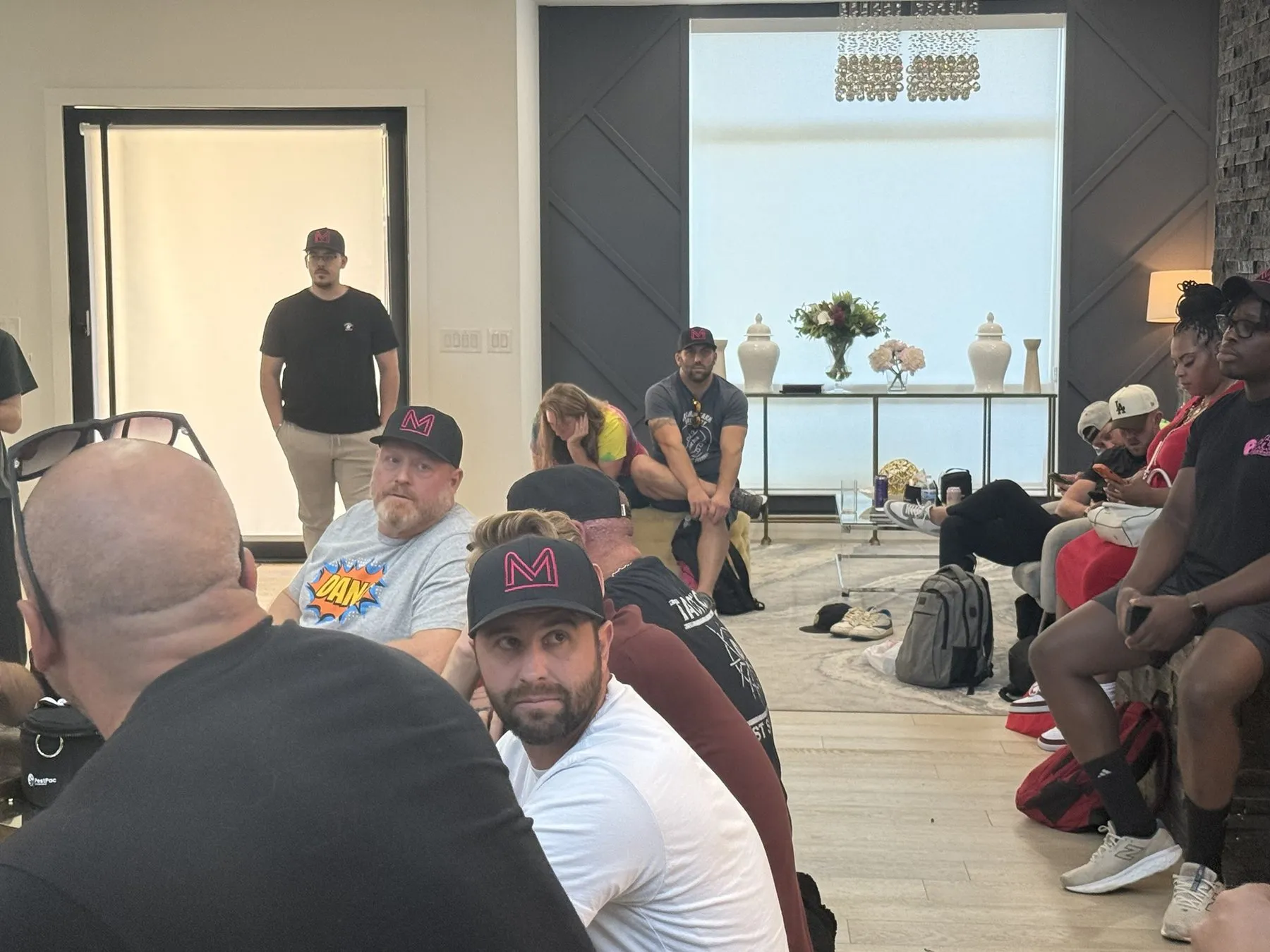 Members in PCM hats during a group session in the living room at PCM House