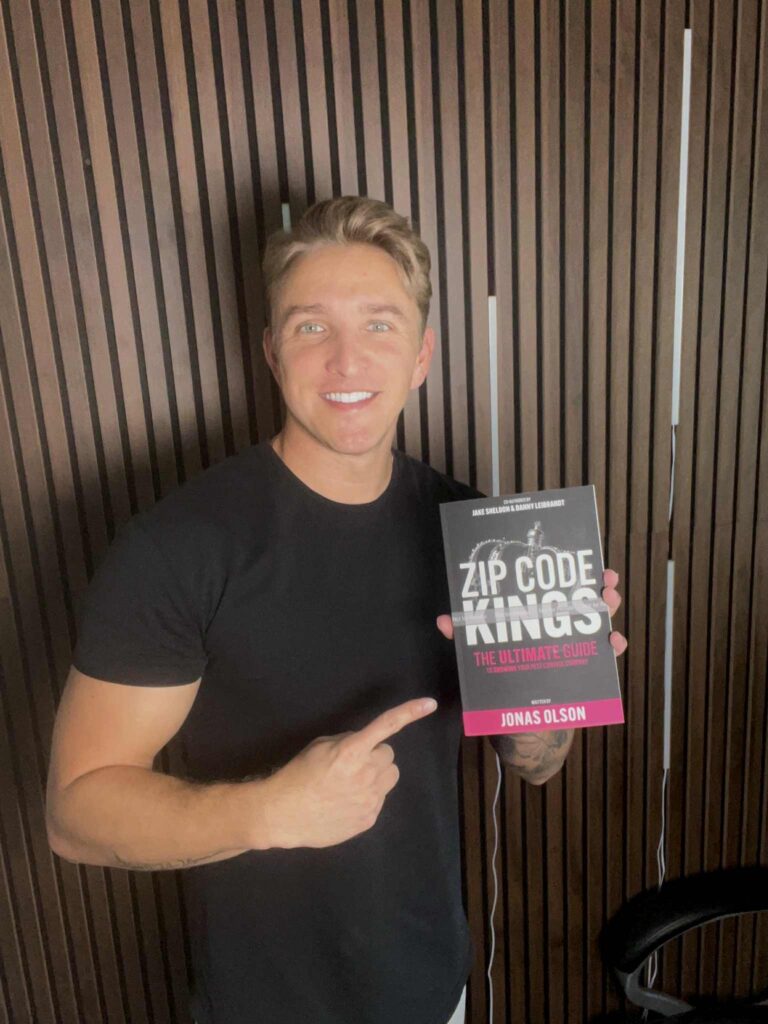 Jake Sheldon holding Zip Code Kings book