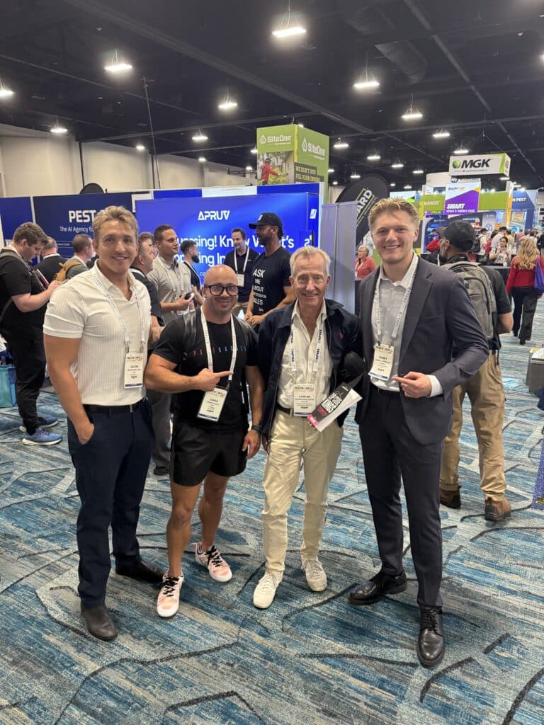 Group of pest control company owners networking at PestWorld 2025 with Zip Code Kings books in hand